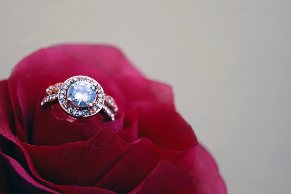 Closeup Photography of Clear Jeweled Gold-colored Cluster Ring on Red Rose